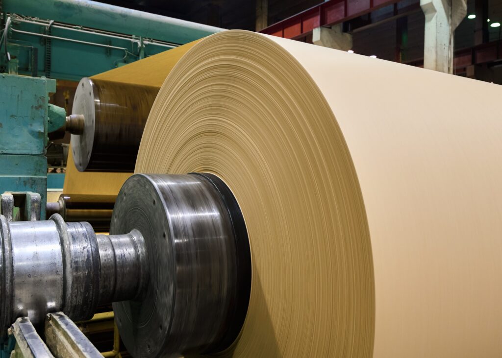 Large roll of brown paper in a paper manufacturing plant during production
